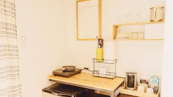 Una cocina con una máquina de café Halas, un escurridor de especias amarillo y una cita enmarcada en la pared.