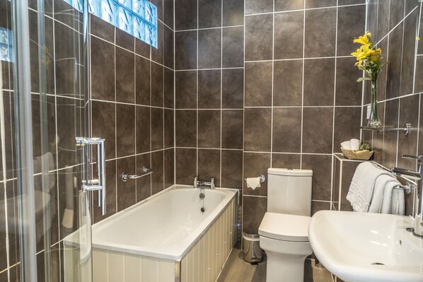 A modern bathroom with a bathtub, toilet, and sink. - The Bay Hotel (Helston)