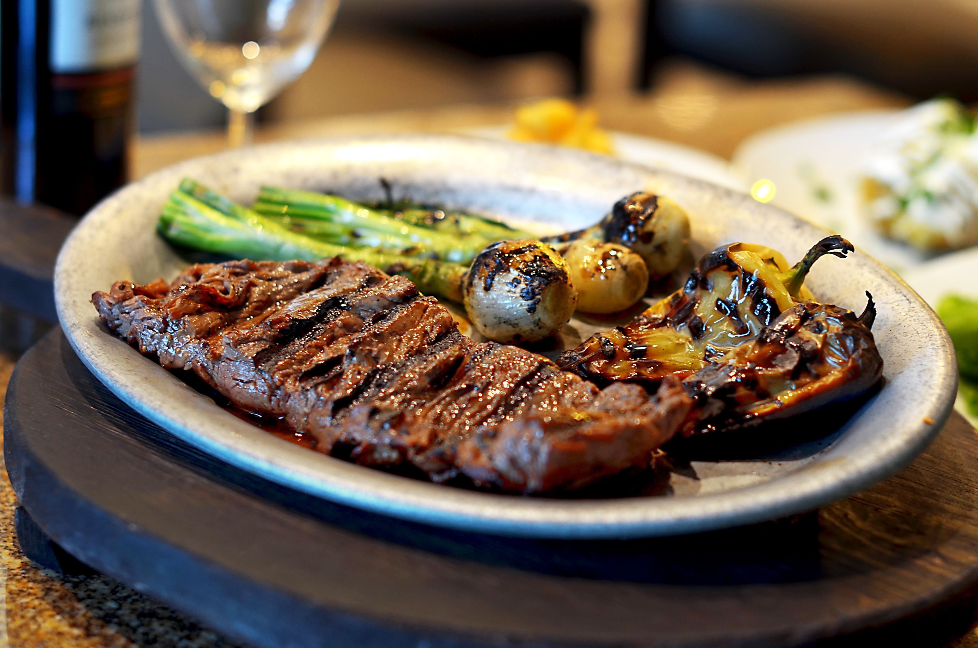 A plate of grilled steak with asparagus and grilled vegetables.