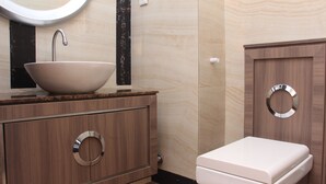 Un bagno moderno con un mobile bagno in legno, un lavabo bianco e un water.