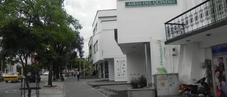 Ein Hotel namens "Hotel Aires del Quindio" mit heller Fassade und einem Balkon mit dekorativen Eisenverzierungen.