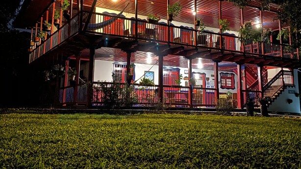 A two-story building with a balcony, a staircase, and a well-lit entrance. - Finca Cafetera El Balso (Armenia)