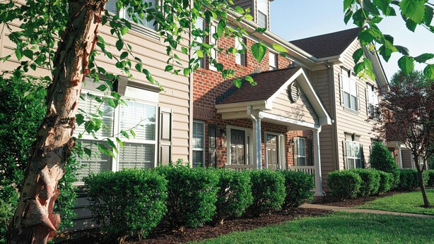 A two-story residential building with a brick facade, a covered porch, and a well-maintained lawn. - Vacation Village at Williamsburg (Williamsburg)