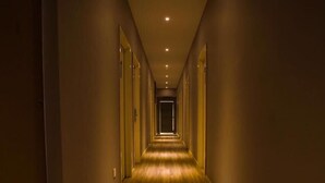 Un pasillo largo y estrecho con suelo de madera e iluminación empotrada.