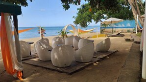 A beachside seating area with wicker chairs and a wooden deck. - Brazaville Beach Resort (Hinoba-an)