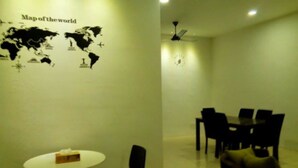 Una habitación con un mapa mundial en la pared, una mesa redonda con sillas y un ventilador de techo.