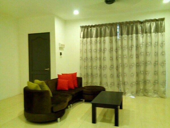 A living room with a dark brown sofa, a small table, and a door.