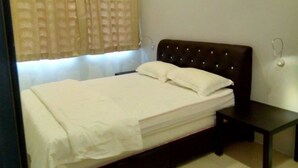 Una cama bien hecha con sábanas blancas en una habitación con cabecera oscura y una mesita de noche pequeña.