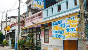 A hostel with a prominent sign advertising a price of 63 units of currency. - Zleep63 - Hostel (Bangkok)