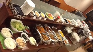 Un bufé con diversos alimentos y recipientes.