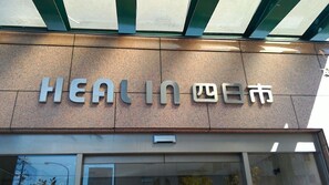 Un bâtiment sur lequel on peut lire l’inscription suivante : « HEAL IN Yokkaichi ».