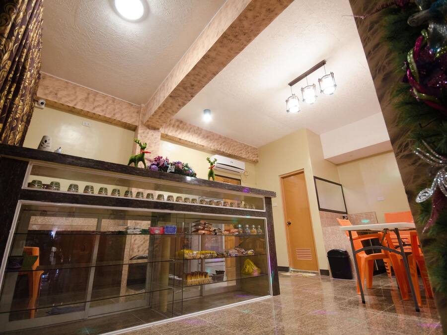 A hotel lobby with a glass display case filled with snacks, a reception desk, and a Christmas tree.