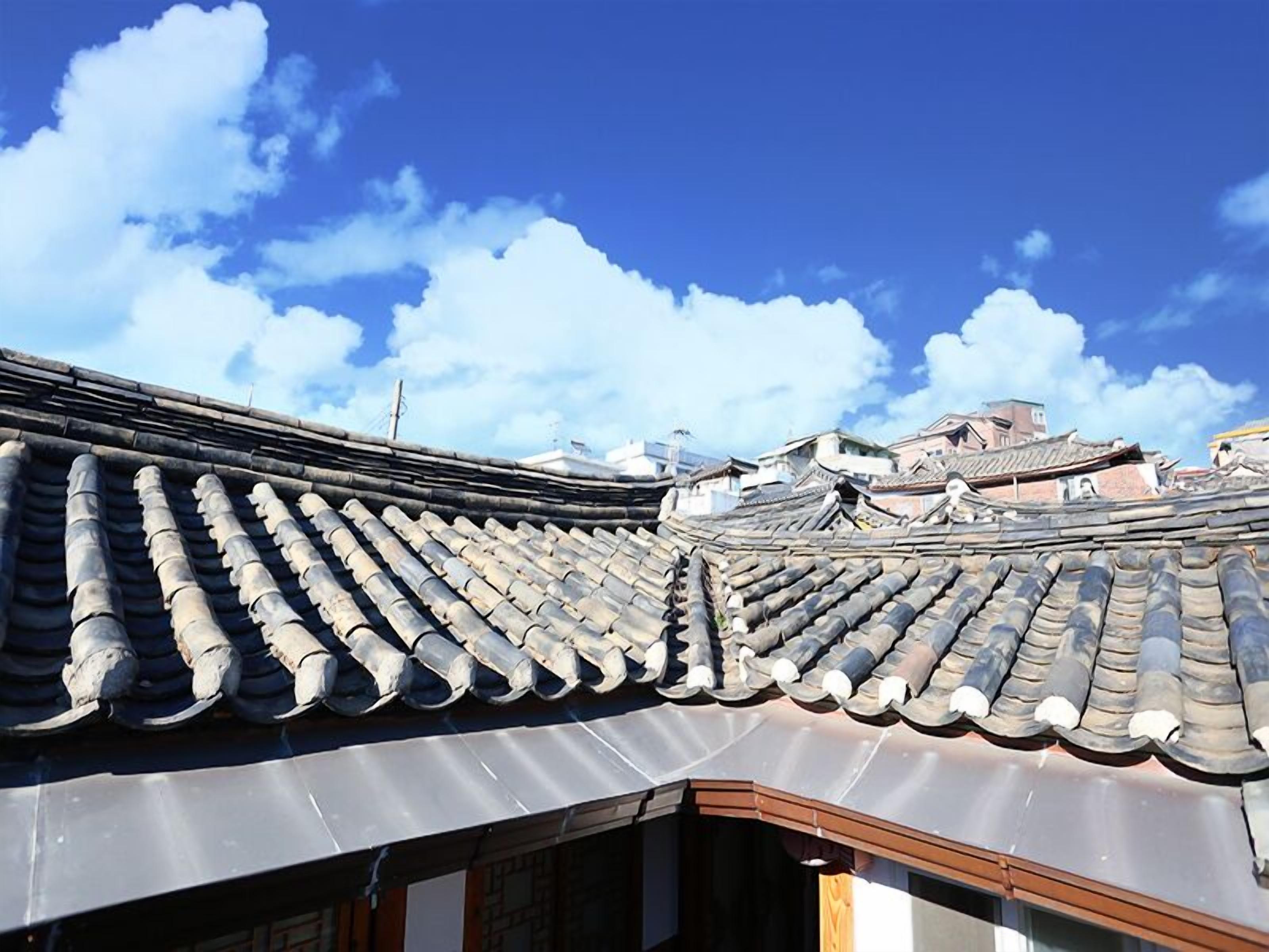 Un tejado japonés tradicional con tejas curvas y un cielo azul despejado.