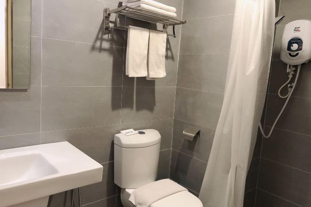 A modern bathroom with a toilet, sink, and a hand dryer.