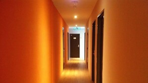 Un pasillo de hotel con pisos de madera y paredes anaranjadas.