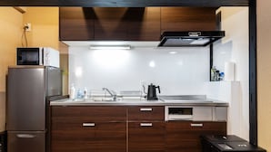 A compact kitchen with a built-in microwave, refrigerator, and dishwasher. - Shiki Homes NATSU (Kyoto)