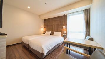 A modern hotel room with a large bed, a desk, and a chair.