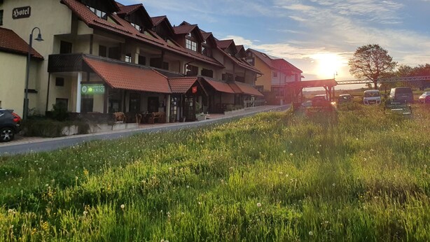 A row of traditional buildings with a sign indicating a hotel. - Berggasthof & Hotel Hinterrod (Eisfeld)