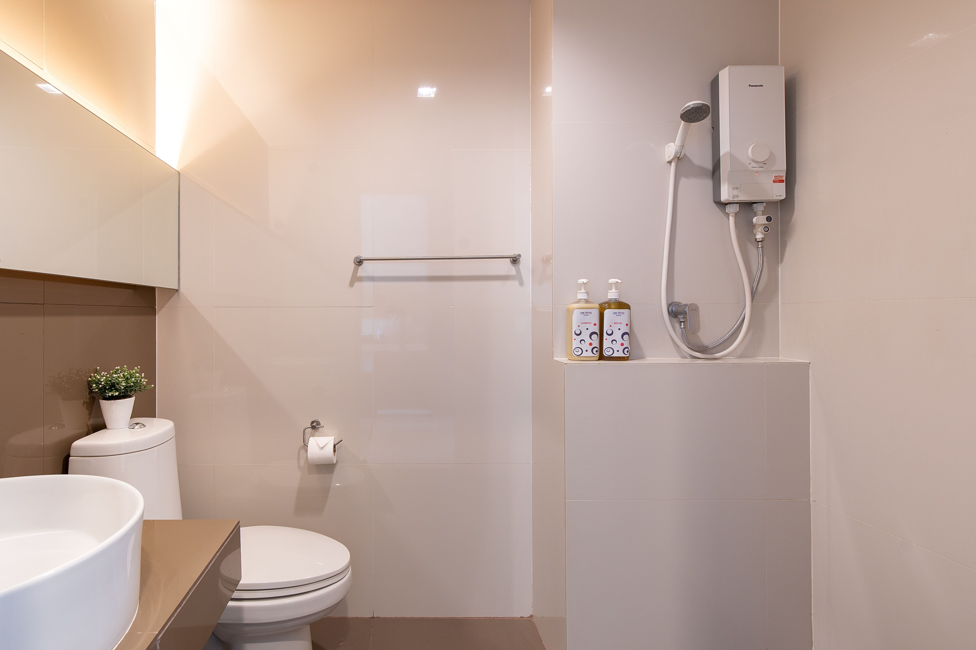 A modern bathroom with a toilet, sink, and shower.