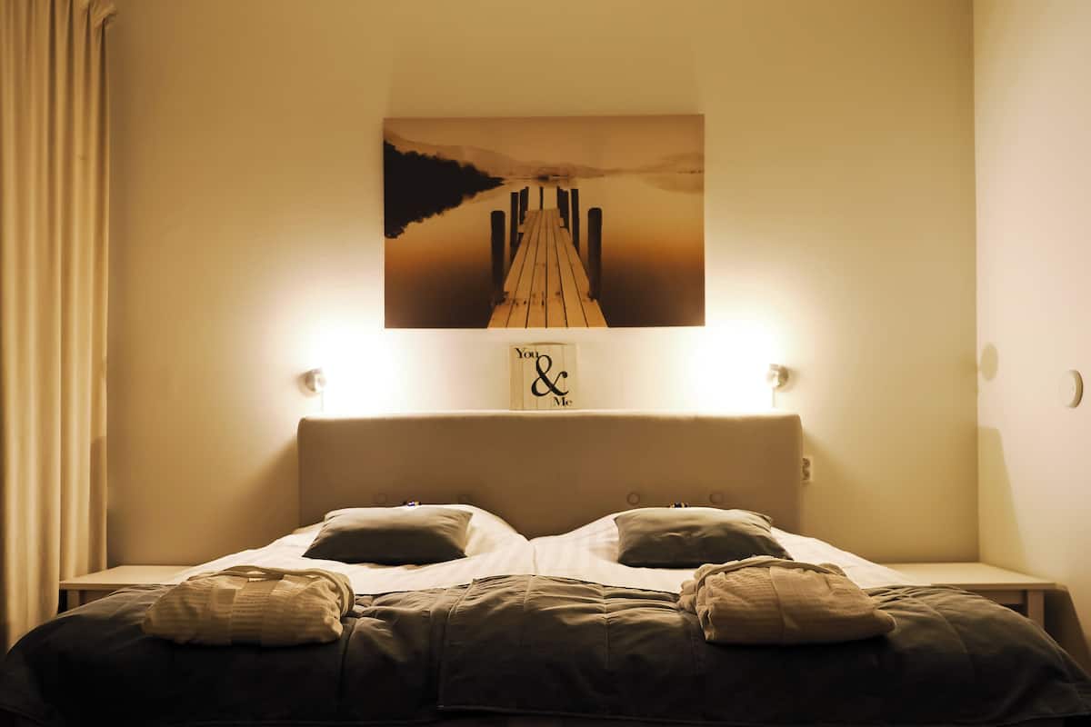 A bed with a headboard, two pillows, and a blanket.