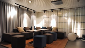Una sala moderna con un sofá modular, otomanas, una mesita de centro y un objeto esférico blanco de gran tamaño.