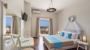 Habitación de hotel con cama, mesitas de noche, una silla, televisión y vistas a la ciudad.