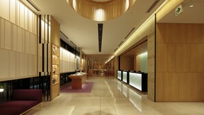 A modern hotel lobby with a central reception desk, a seating area with a sofa, and a decorative ceiling with vertical wooden slats. - Candeo Hotels Osaka Namba (Osaka)