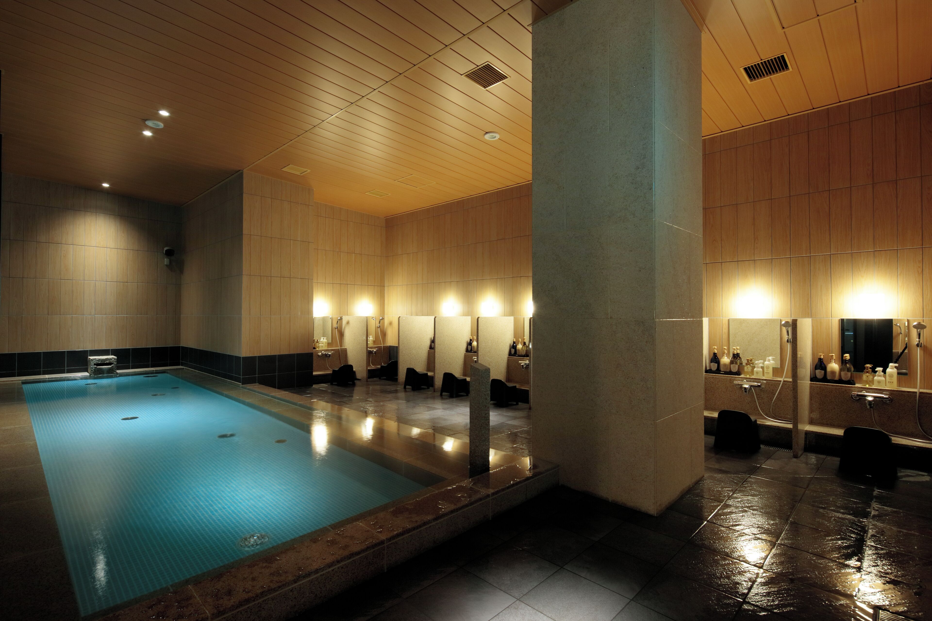 A swimming pool with a tiled floor and a wooden ceiling.