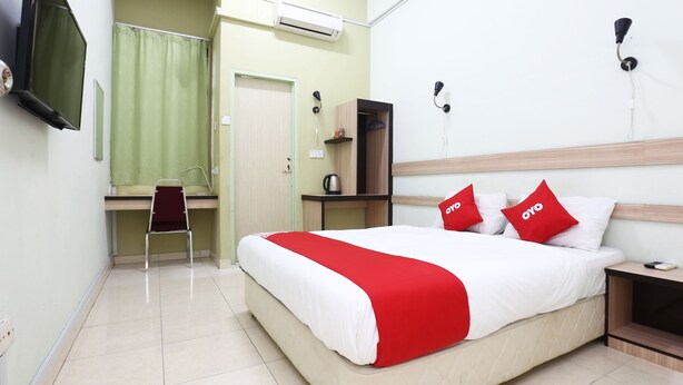Une chambre d’hôtel équipée d’un lit, d’un bureau, d’une chaise, d’une télévision et d’une armoire.