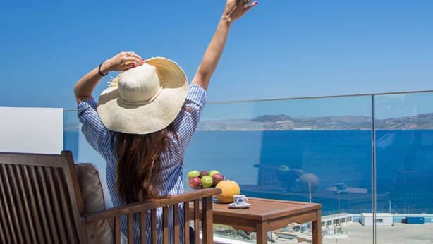 Una persona sentada a una mesa con vista al mar.