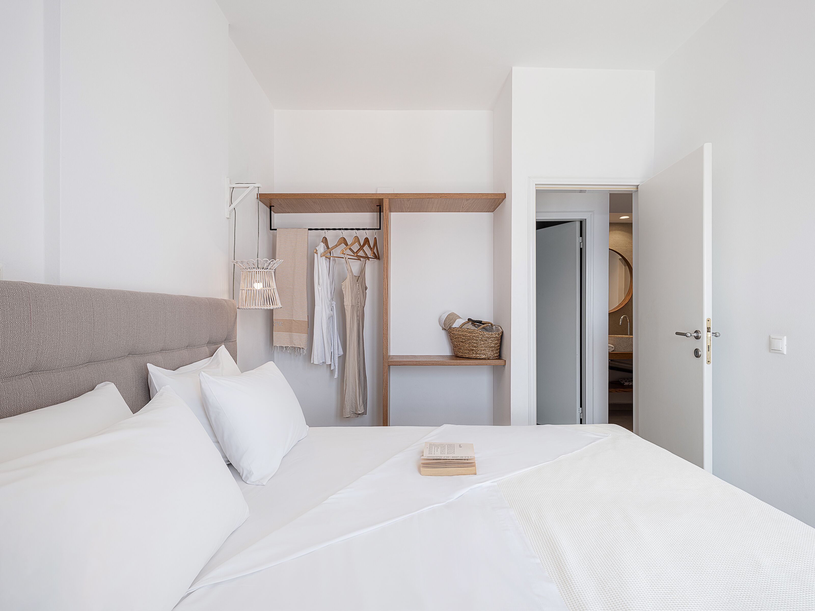A bedroom with a bed, a wardrobe, and a bathroom door.