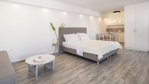 Un dormitorio moderno con cama, mesita de noche y una pequeña mesa redonda.