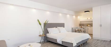 A modern bedroom with a bed, bedside table, and a small round table.