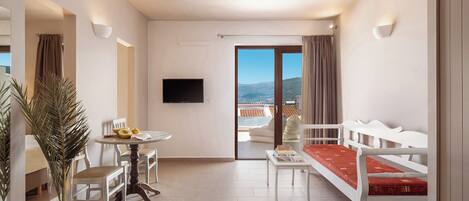 A modern hotel room with a balcony, a dining area, and a seating area.