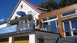 Ett hotell med en balkong som har en skulptur föreställande människor.