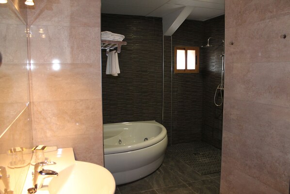 A bathroom with a bathtub, a shower, and a sink. - Hotel Los Barruecos (Malpartida de Caceres)