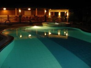 A swimming pool at night with lights reflecting on the water.