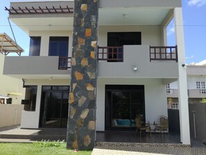 A two-story house with a stone pillar, large windows, and a balcony. - Happy Villa (Trou aux Biches)