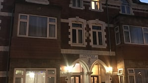 A two-story building with a prominent entrance, a sign reading "Anchorage Guest House," and multiple windows. - WiseStay (Cardiff)