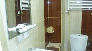 Une salle de bain avec un lavabo blanc, des toilettes et un miroir.