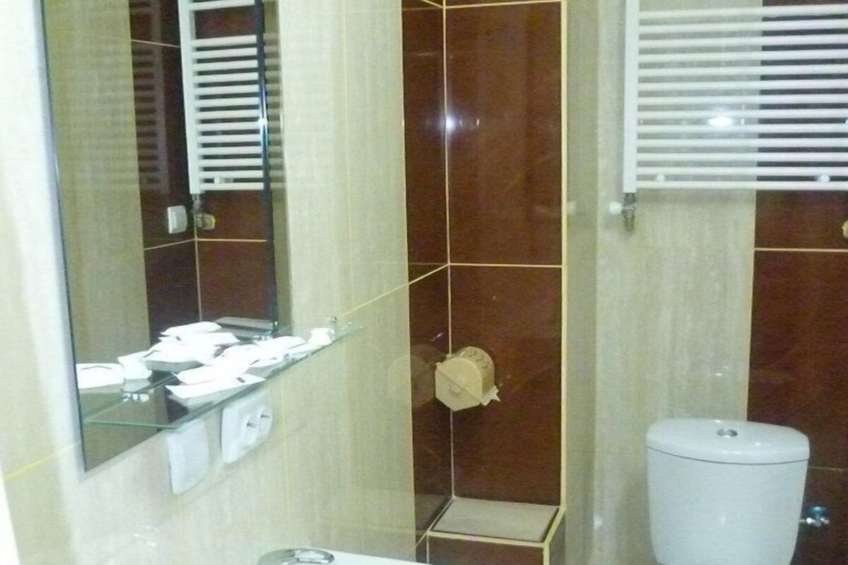 A bathroom with a white sink, a toilet, and a mirror.