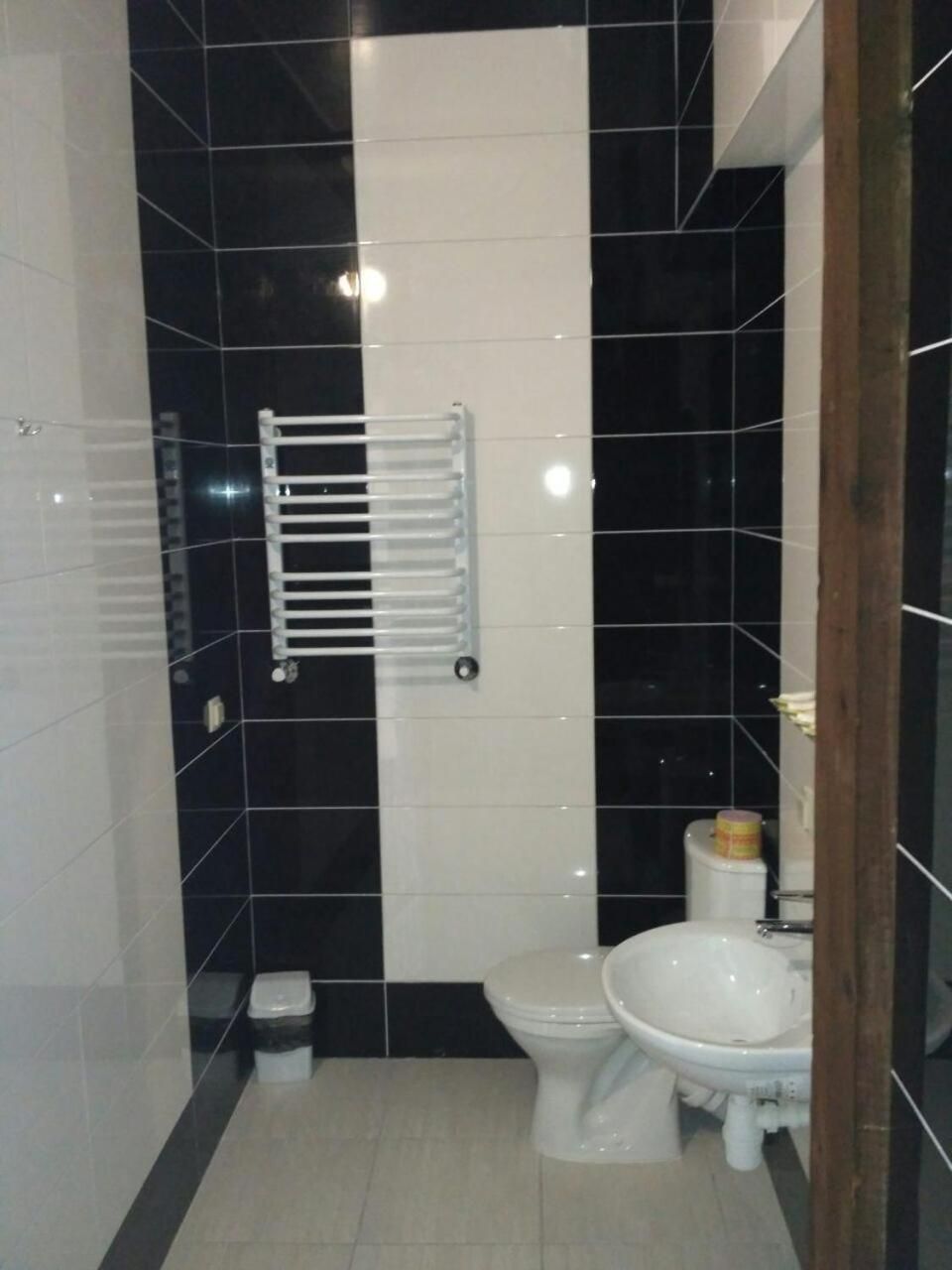 A bathroom with a toilet, bidet, and a towel rack.