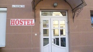 Une auberge de jeunesse avec une porte blanche et une enseigne sur le mur indiquant « AUBERGE ».