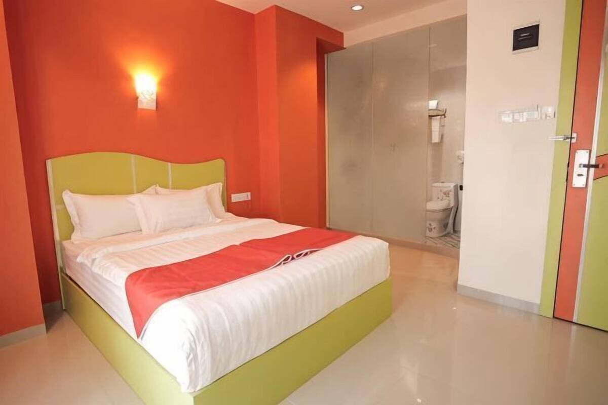 Een hotelkamer met een bed, een badkamer en een deur.