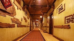 A hallway with patterned carpet, wooden walls, and a wooden ceiling. - Tuado Hotel (Baku)