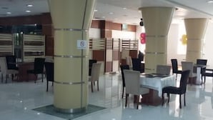 A spacious indoor area with high ceilings and modern furnishings, including tables and chairs arranged for dining or meetings. - Tuado Hotel (Baku)