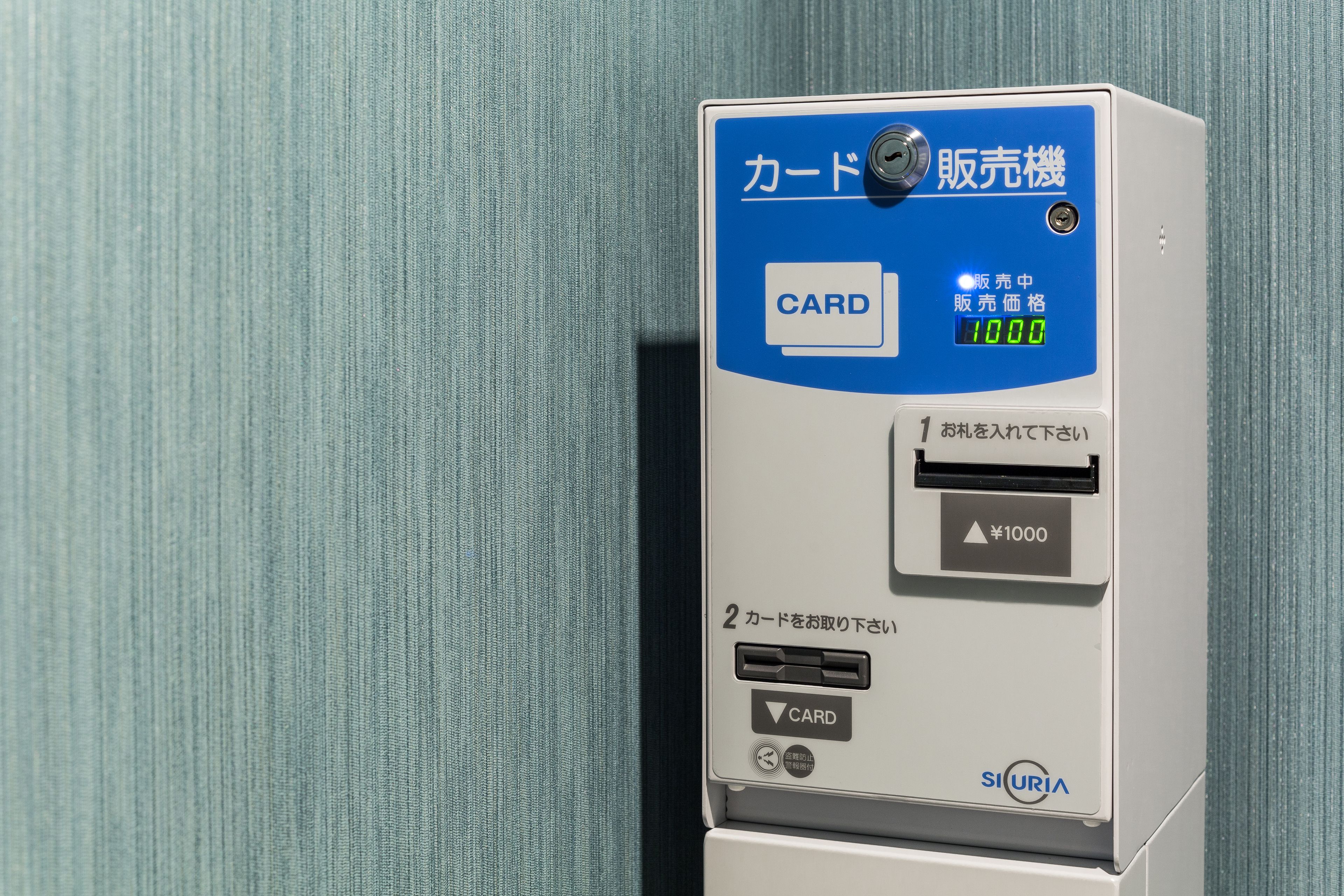 A card reader with Japanese text, a digital display, and a cash slot.