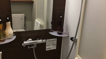 A bathroom with a dark wood vanity, a mirror, a towel rack, and a shelf with toiletries.