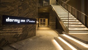 Un interior de hotel moderno con una pared de mármol y un cartel que dice 'Darmy Inn Premium'.