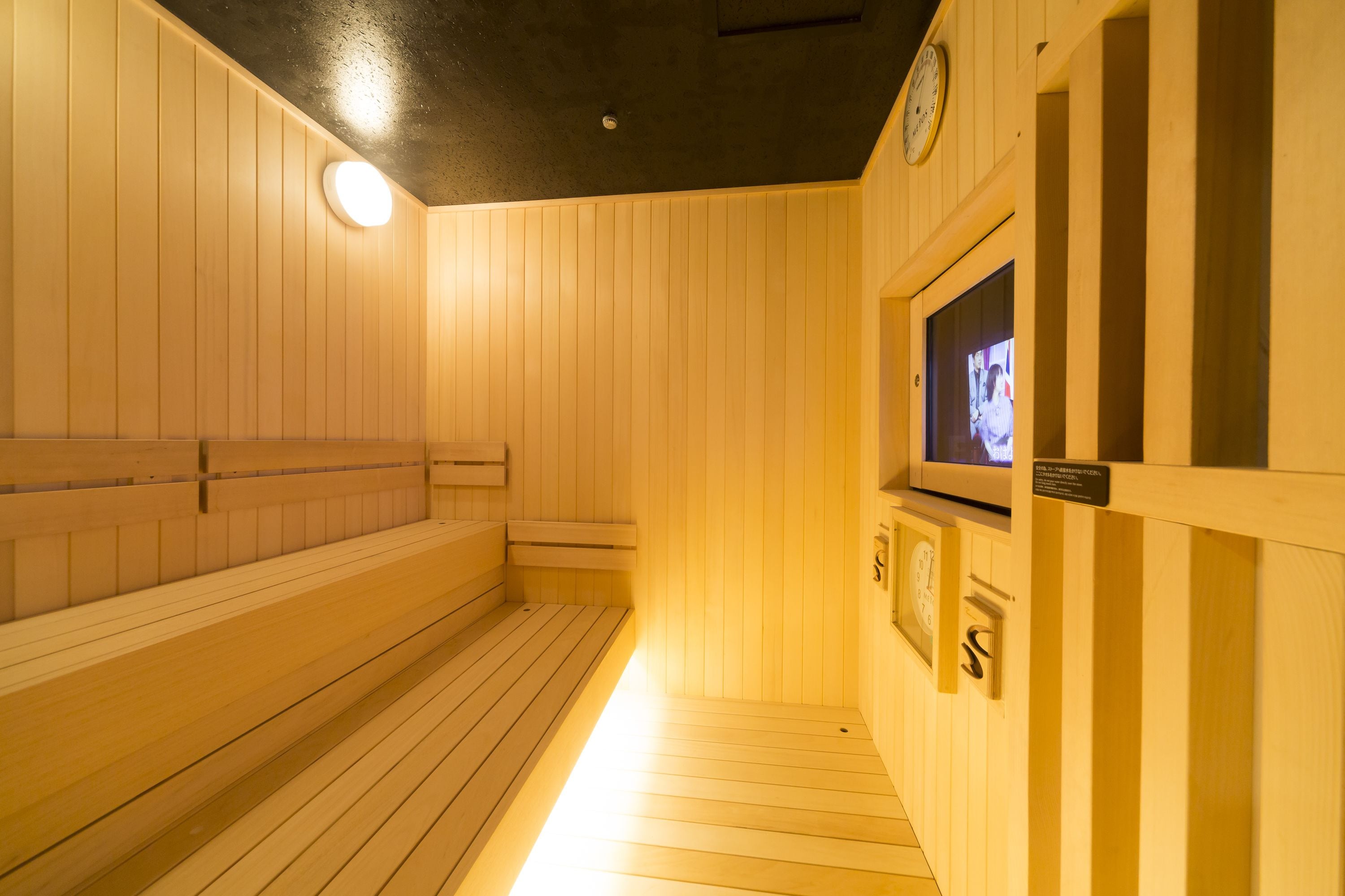 Puisesta laudelavasta ja televisiosta varustettu sauna.